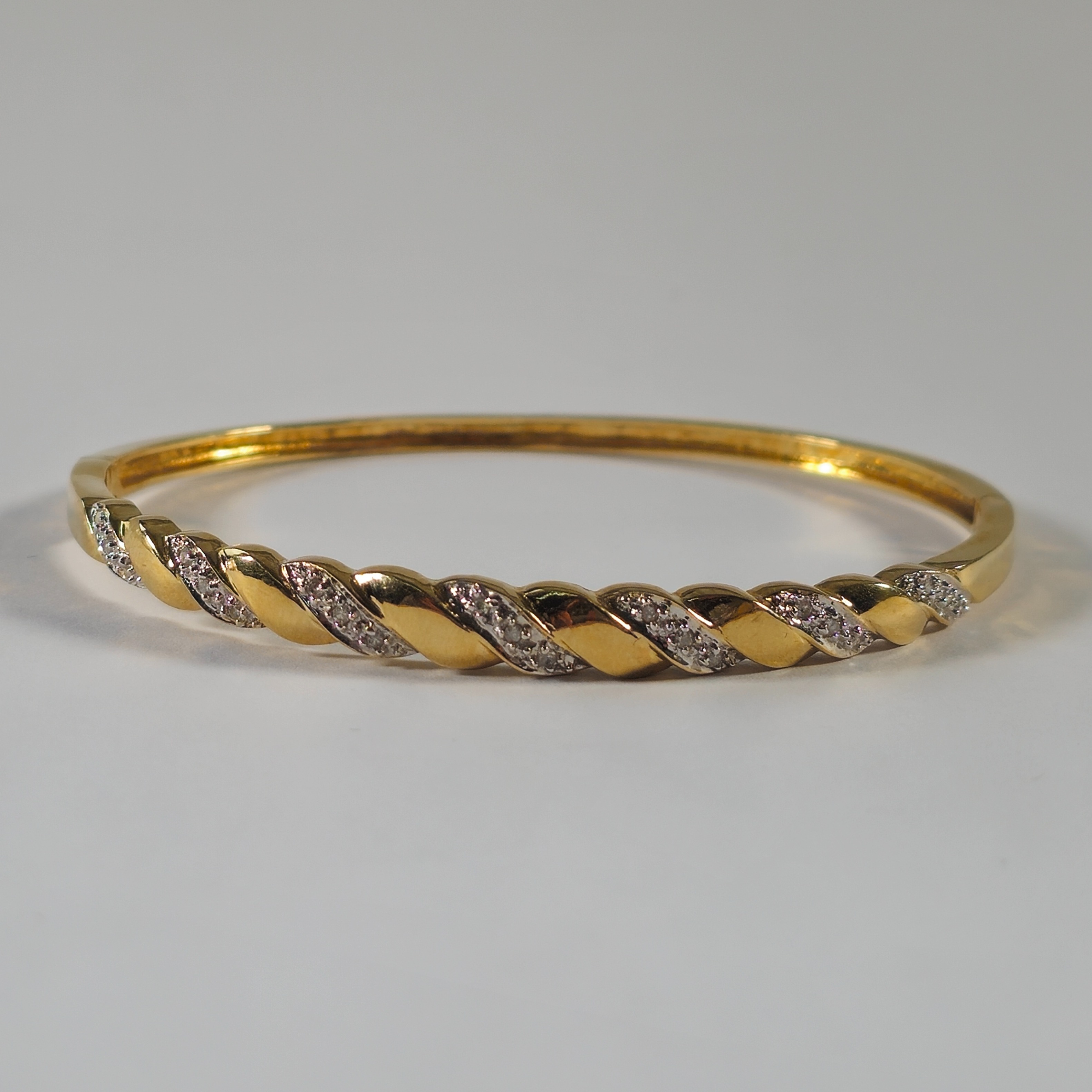 Product photo for 9ct Gold 0.15ct Small Diamond Twisted Wrap Style Hinge Bangle