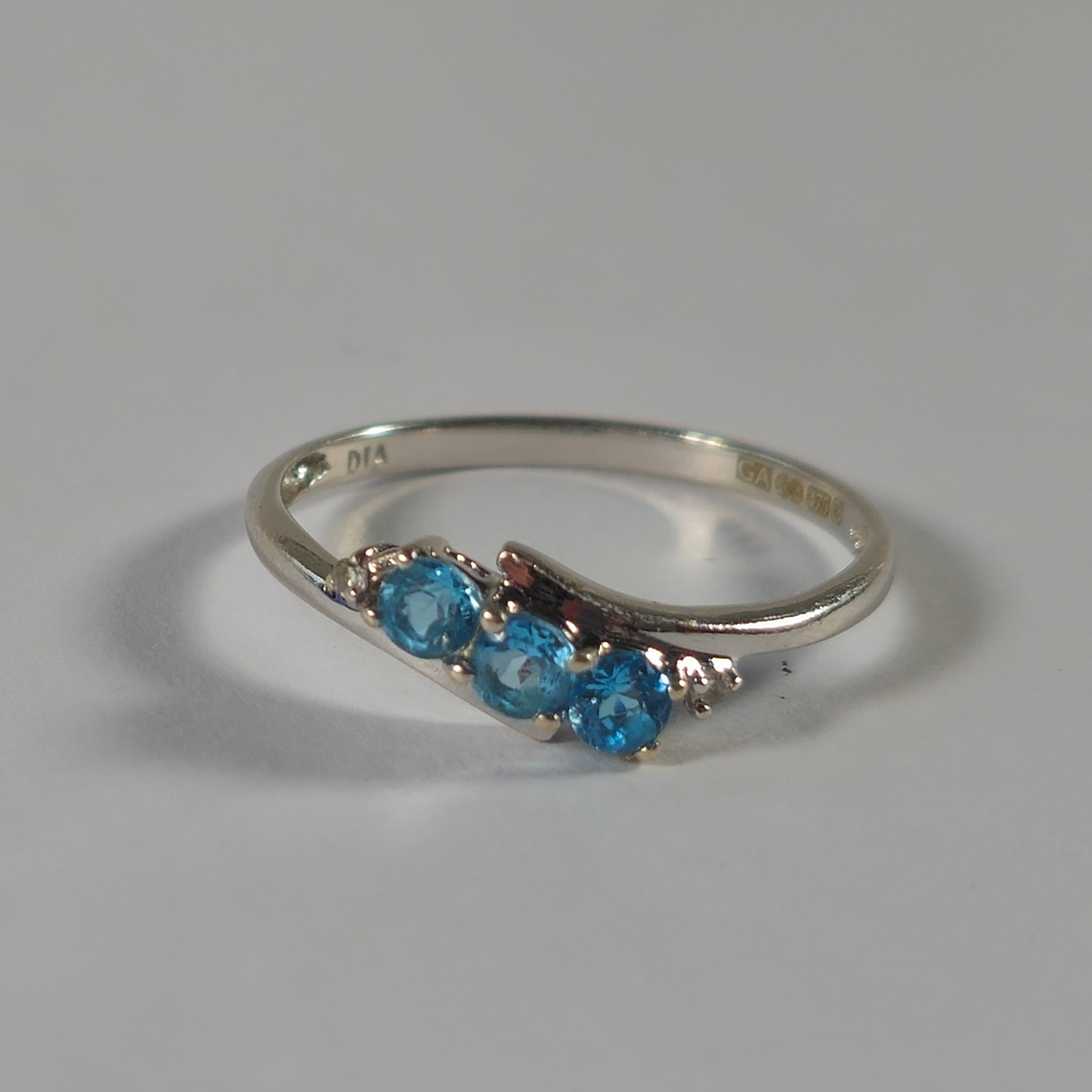 Product photo for 9ct White Gold Round Blue Stone & Diamond Trilogy Kissing Style Ring Size N