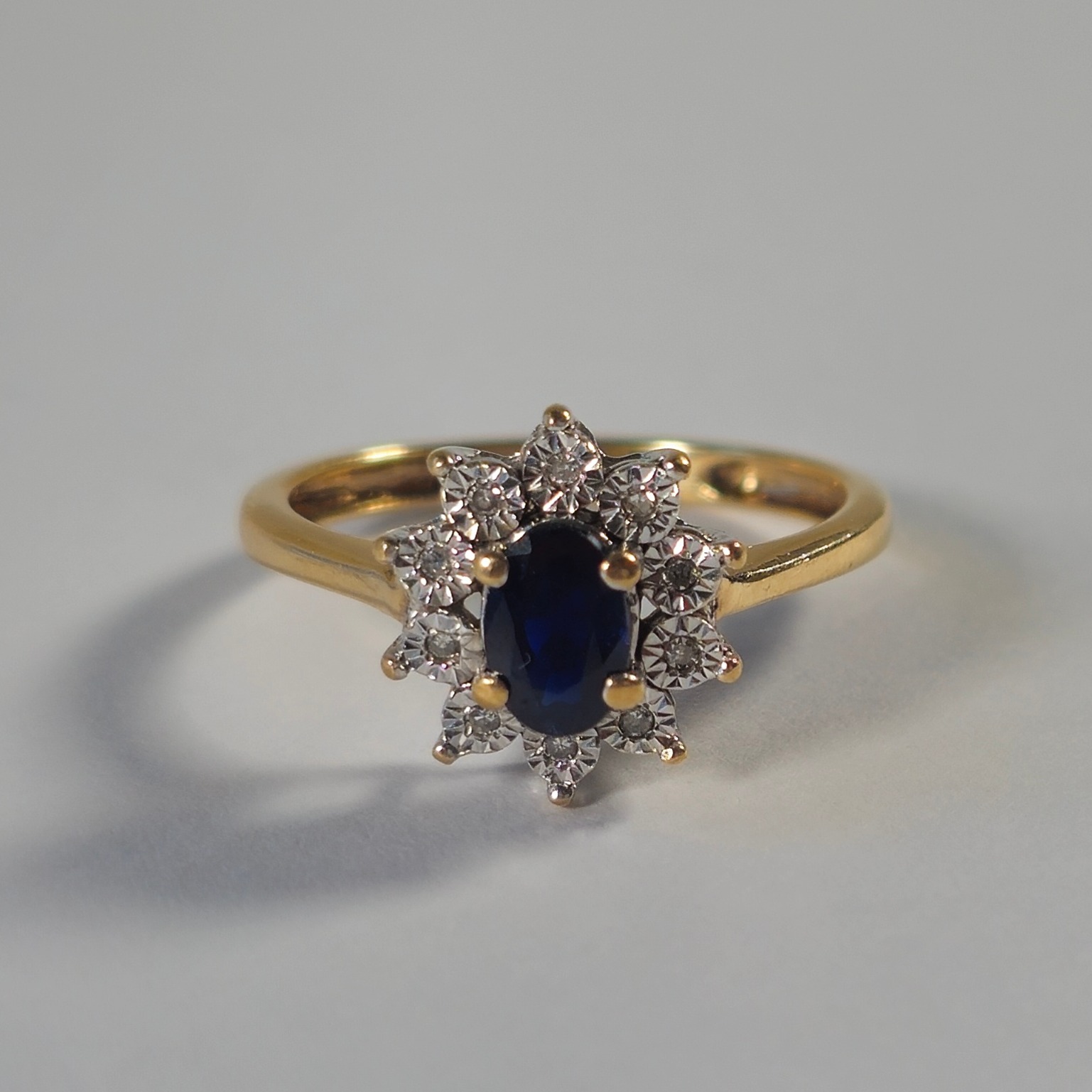 Product photo for 9ct Gold Oval Blue Sapphire & Tiny White Stone Flower Ring Size M
