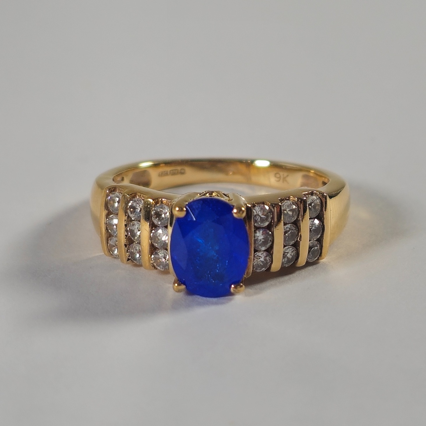 Product photo for 9ct Gold Oval Blue Synthetic Stone &*CZ* Solitaire Style Ring Size N