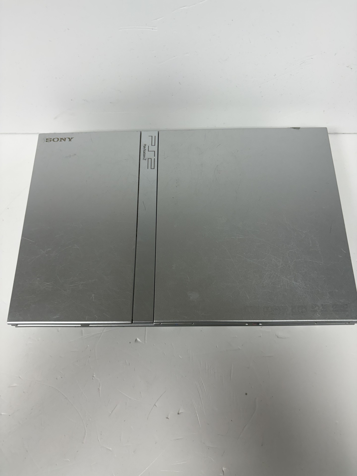 Product photo for PlayStation Slim 2 silver with one controller unboxed